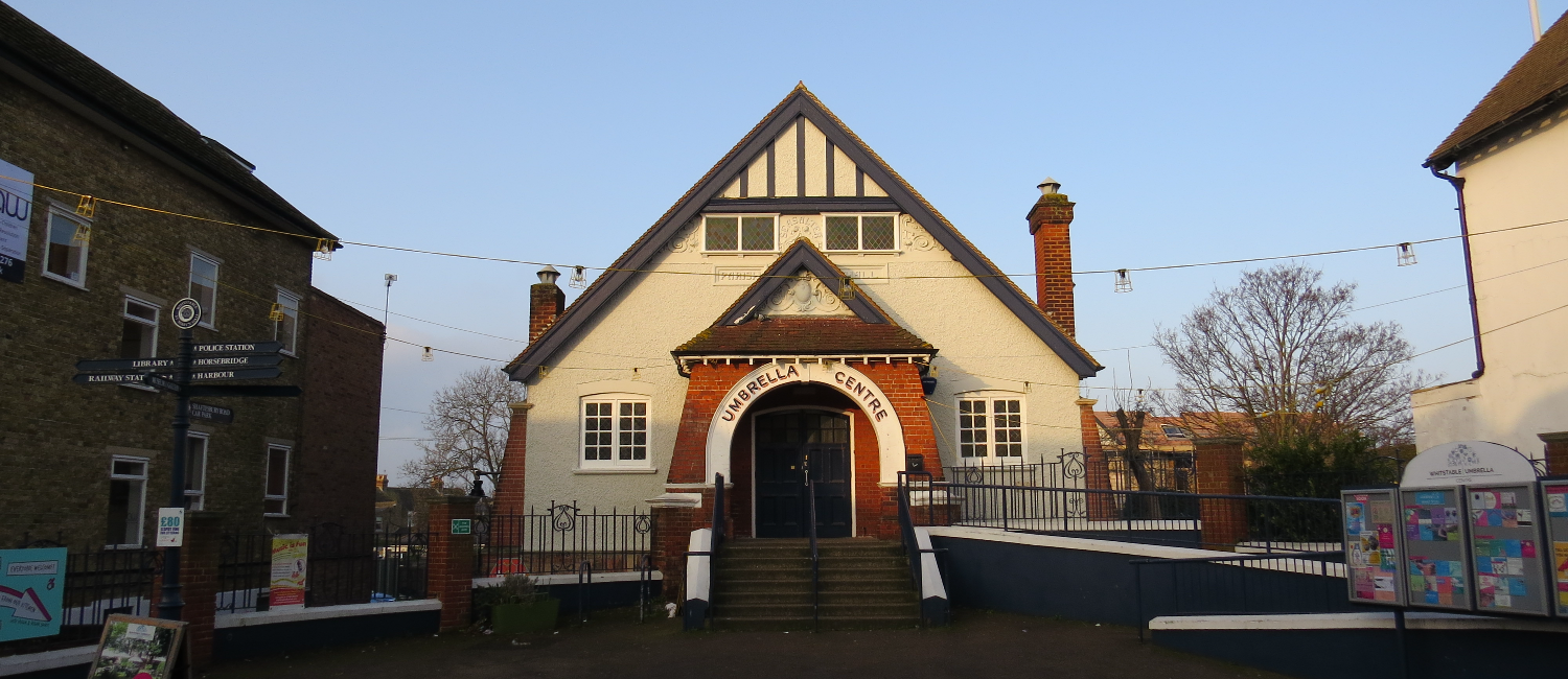 Image of the Whitstable Umbrella Centre, a cream buildin g with a red brick entrance arch.